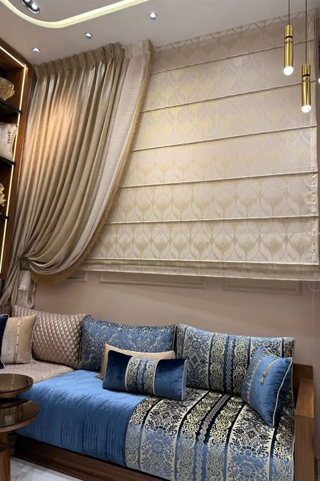 tapisserie marocaine contemporaine dans un intérieur luxueux avec canapé en tissu damassé, coussins décoratifs, rideaux et store romain, ambiance élégante et raffinée